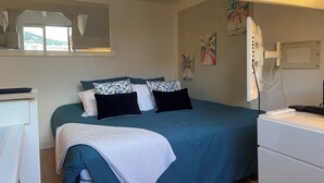 Ein Schlafzimmer mit einem Bett, einem Schreibtisch und einem Fenster.