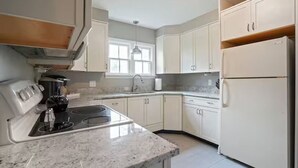 A kitchen with white cabinets, a stove, and a refrigerator. - The Franklin Suite- Near Jennings Sports Complex (Lewis Center)