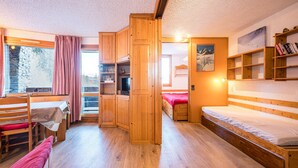Ein Zimmer mit einem hölzernen Bett, einem Schreibtisch, einem Stuhl und einem Bücherregal.