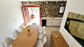 Eine moderne Küche mit Steinwänden, einem Holztisch und einem Blumentopf.