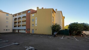 A multi-story parking lot with a yellow building adjacent to it. - Cute little studio for 4 people, parking (Agde)