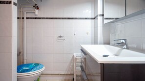 Ein Badezimmer mit einem weißen Waschbecken, einem Spiegel und einer Toilette mit blauem Wellendesign.
