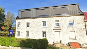 A two-story stone building with a flat roof and a red roof on the right side. - Border Lodge - Comfort just a stone's throw from the border (Évrange)