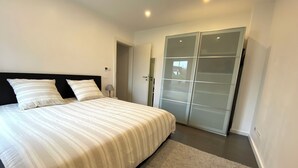 A bedroom with a bed, a nightstand, a lamp, and a wardrobe. - Border Lodge - Comfort just a stone's throw from the border (Évrange)