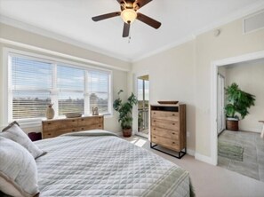 A bedroom with a bed, a wooden dresser, a ceiling fan, and a window with blinds. - Welcome to your slice of paradise! (Englewood)