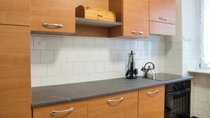A kitchen with wooden cabinets, a countertop, a kettle, and a dishwasher. - Barzio - Garden - Primula (Barzio)