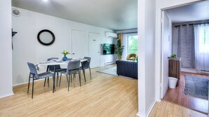 Un espacio habitable moderno con comedor, cocina y balcón.