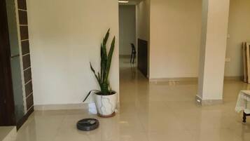 A spacious hallway with a ceiling fan, a potted plant, and a small table with a lace tablecloth.