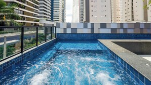 A rooftop swimming pool with a view of high-rise buildings. - Studio w/ Self Check-in in Goiania Liu1606 (Goiânia)