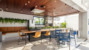 A modern kitchen with wooden ceiling, a bar area, and seating. - Studio w/ Self Check-in in Goiania Liu1606 (Goiânia)