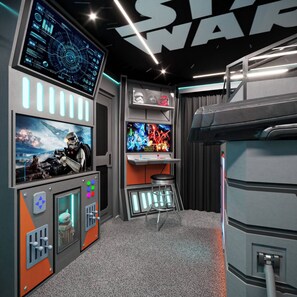 Ein thematisch gestalteter Raum im Stil von Star Wars, mit einem großen Bildschirm, der eine Szene aus Star Wars zeigt, einer Bedienkonsole mit verschiedenen Tasten und einer Bar im Star-Wars-Design.