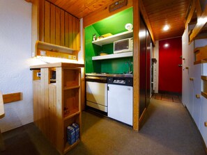 A compact kitchen with a microwave, stove, and refrigerator.