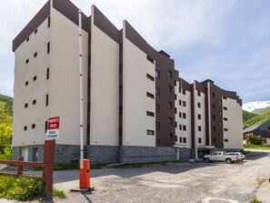 A multi-story hotel with a modern architectural design, featuring a prominent entrance with a sign indicating private residence. - 3-room apartment, sleeps 6, parking, south balcony in Valloire (Valloire)