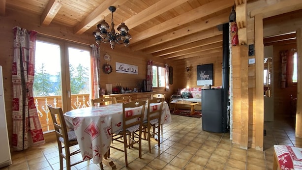 Ein Holzblockhaus-Innenraum mit Essbereich, Küche und Wohnbereich.