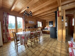 A wooden cabin interior with a dining area, kitchen, and living space. - Savoyard Chalet with WIFI, near ski slopes (Crest-Voland)