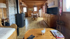 Ein gemütliches Blockhauss-Interieur mit Essbereich, Küche und Wohnbereich.
