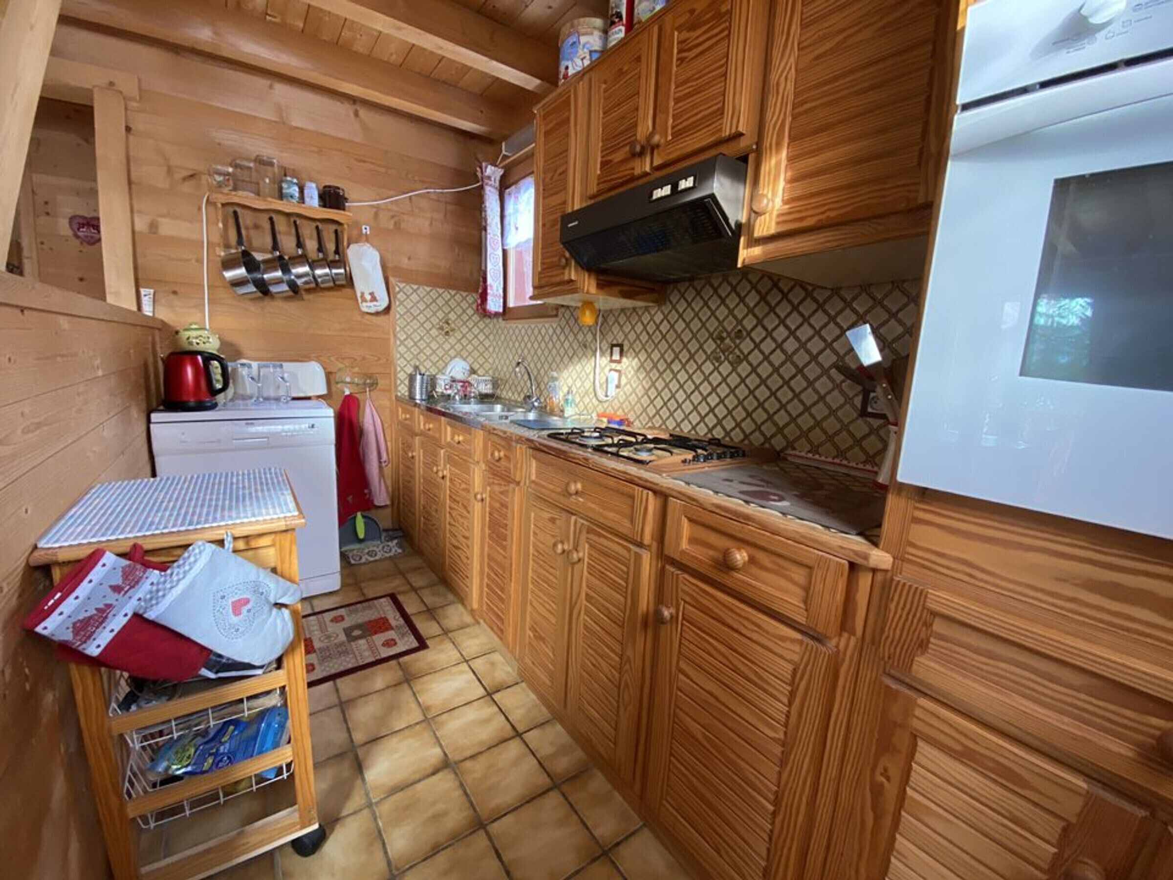 Una cocina pequeña con gabinetes de madera, una estufa y una encimera.