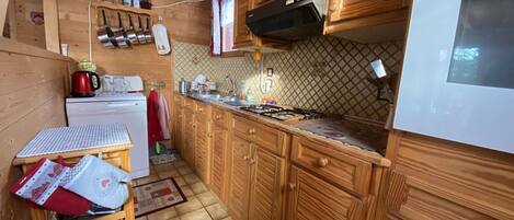 Una cocina pequeña con gabinetes de madera, una estufa y una encimera.