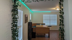A room with a dining table, chairs, a ceiling light, and a sign on the wall. - Candle Maker's Cove: King Bed, Fiber WiFi, Full Kitchen Access (Leander)