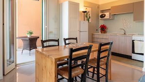 Et moderne køkken med spiseplads, mikroovn, køleskab og en potteplante.