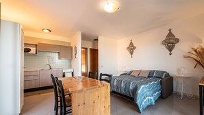 Et moderne køkken med spiseplads, en sofa og et lille bord.
