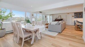 A spacious living area with a dining table, chairs, a sofa, and a kitchen area with a dining table and chairs. - Coastal Retreat at Lemon Tree Cottage (Marion)