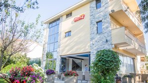 A modern hotel with a stone facade, large windows, and a visible entrance. - Glory Sanctuary Retreat (Citluk)