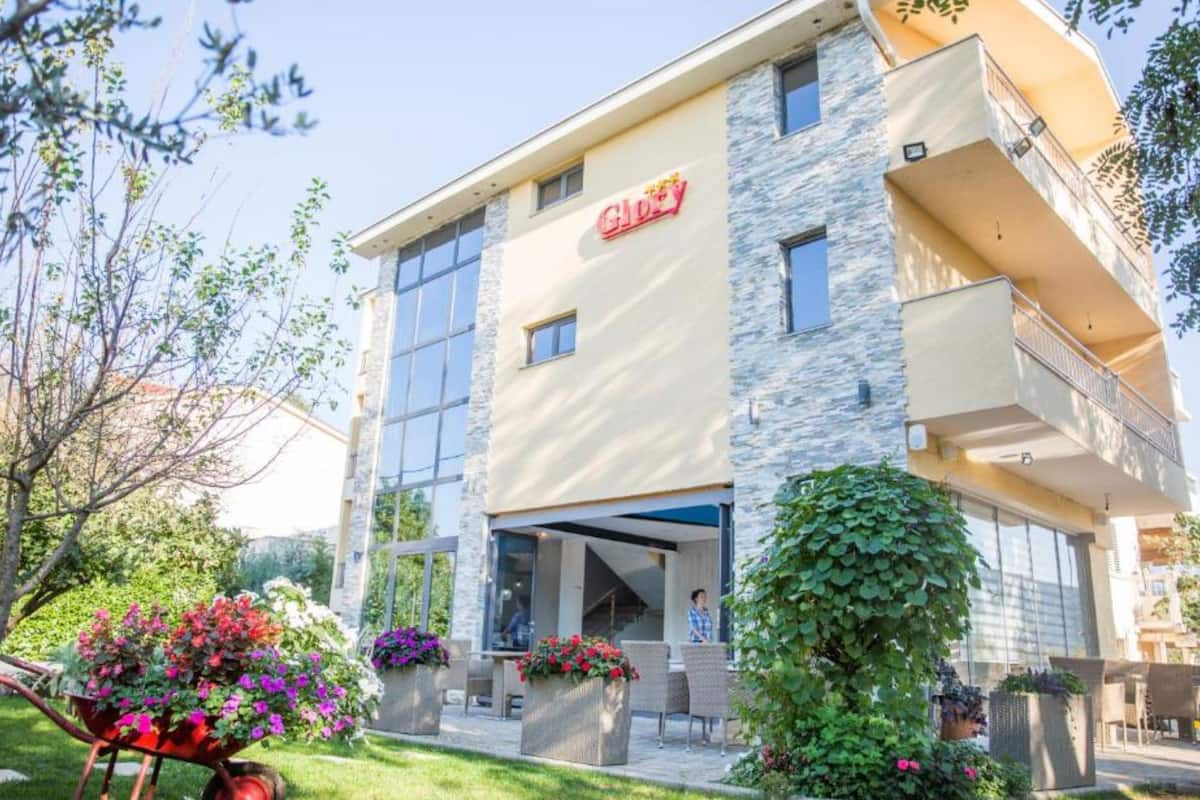 Un hôtel moderne avec une façade en pierre, de grandes fenêtres et une entrée bien visible.