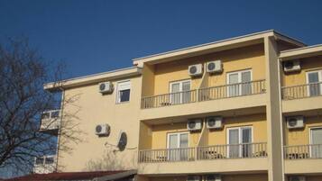 A multi-story building with balconies and air conditioning units.
