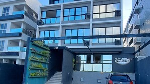 Un edificio moderno con varios pisos, ventanas grandes y un letrero que dice "Flat Santorini 251".