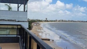 Un balcón con vista a una playa y al océano.