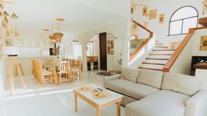 A spacious living area with a staircase, a dining set, and a sofa. - House with Private Pool - 3BR Cancun Downtown Zone (Cancún)