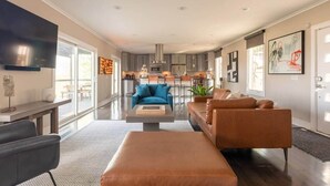 Un salon moderne avec un canapé, une table basse et un téléviseur.