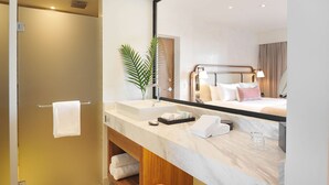 Un baño moderno con un espejo grande, un lavabo y una ducha.