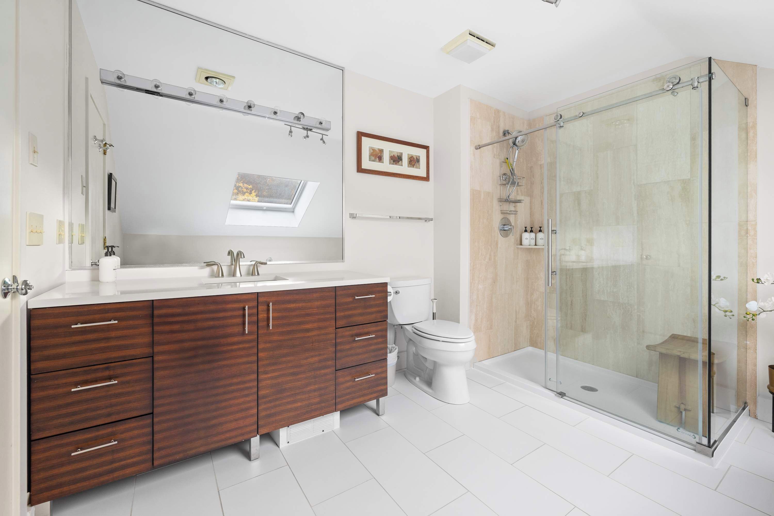 Ein modernes Badezimmer mit Waschtisch, Toilette und einer Duschkabine.