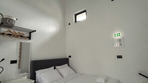 A bedroom with a bed, a bedside table, a mirror, and a ceiling light fixture. - BH1039 - A -Nektar Studio (7H9J+JXC Latsida, Greece)