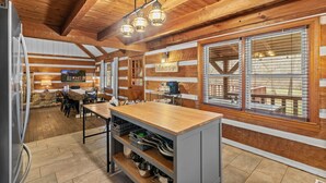 A rustic kitchen with wooden beams, a wooden countertop, and a stone wall. - Waterfront cabin w/fireplace, hot tub & BBQ grill (Maurertown)