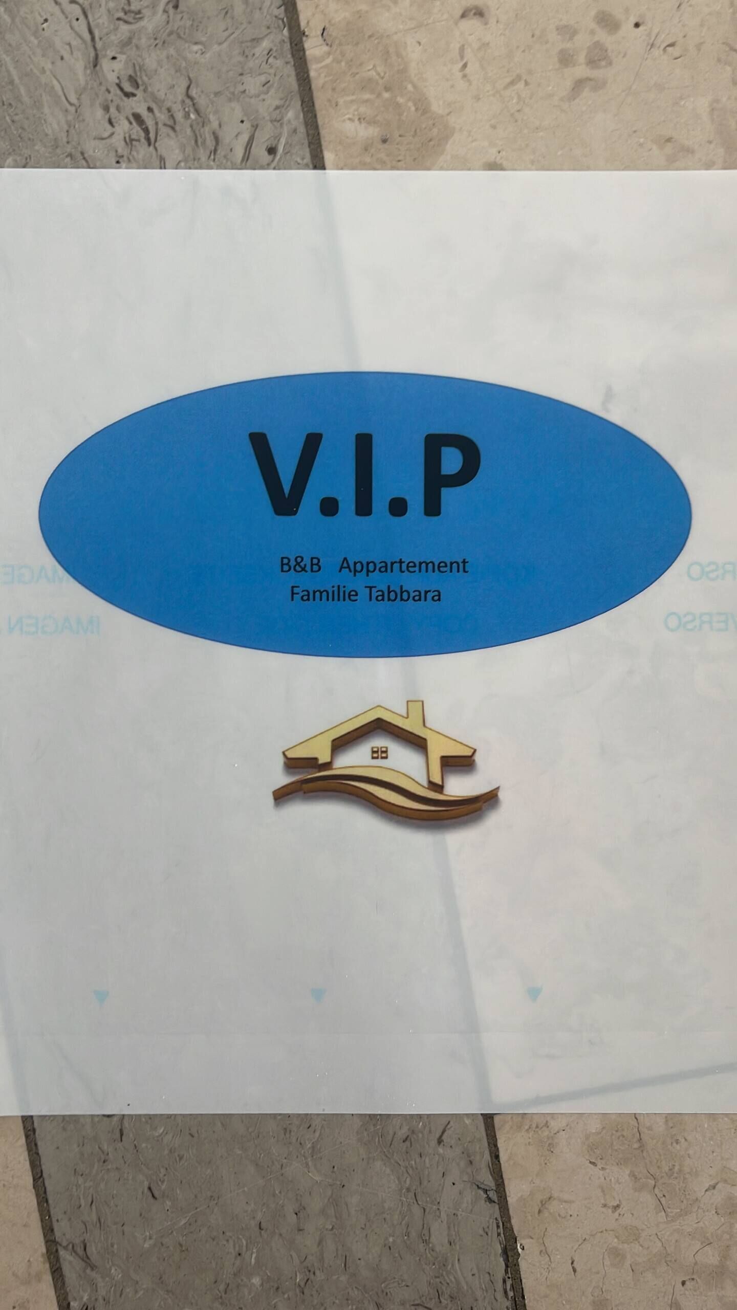 Opastekyltti, jossa lukee ”V.I.P.” ja ”B&B Appartement Famille Tabbara”, osoittaa VIP-tason ja bed & breakfast -tyyppisen majoituksen sijainnin.