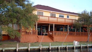 A two-story building with a balcony, a dock, and a small boat.