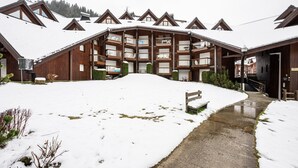 A wooden lodge with multiple balconies and a snow-covered landscape. - Le Cocon des Pistes - Station à 10 minutes (Les Contamines-Montjoie)