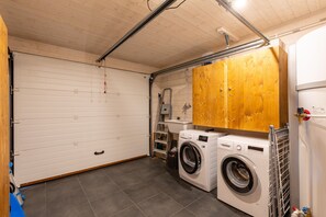 A laundry room with two washing machines, a wooden cabinet, a sink, and a ladder. - Chalet Serra Del Cadi - Vue montagne (Font-Romeu)