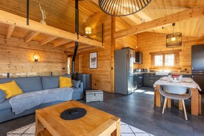 A log cabin interior with a living area, kitchen, and dining space. - Chalet Serra Del Cadi - Vue montagne (Font-Romeu)