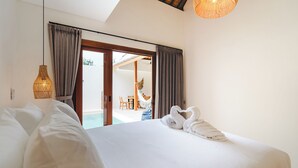 A bedroom with a large bed, two hanging lamps, and a view of an outdoor area with a pool and furniture. - Stylish 2BR Private Pool Villa • 5 Mins to Bingin Beach (Bali)