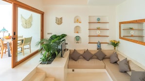 A modern living room with a sofa, decorative wall shelves, and a large mirror. - Stylish 2BR Private Pool Villa • 5 Mins to Bingin Beach (Bali)