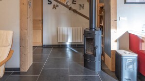 A room with a wood-burning stove, a wooden door, and a radiator.