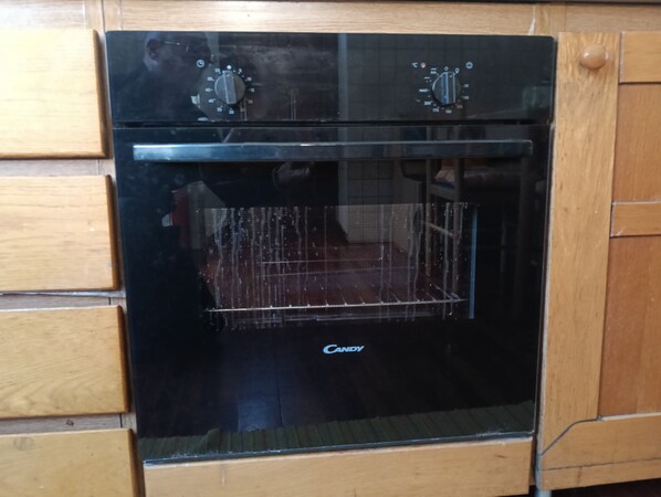 Um forno preto com duas manivelas e a marca visível.