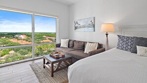 A bedroom with a large window, a bed, a sofa, a lamp, and a painting. - 🏖️Beautiful Views-Lagoon Pool-Hot Tub-Walk2Beach-Luau II- By the Sea☀️ (Miramar Beach)