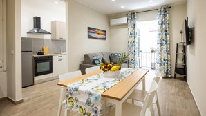 Un espai habitable pràctic amb cuina, zona de menjador i balcó.