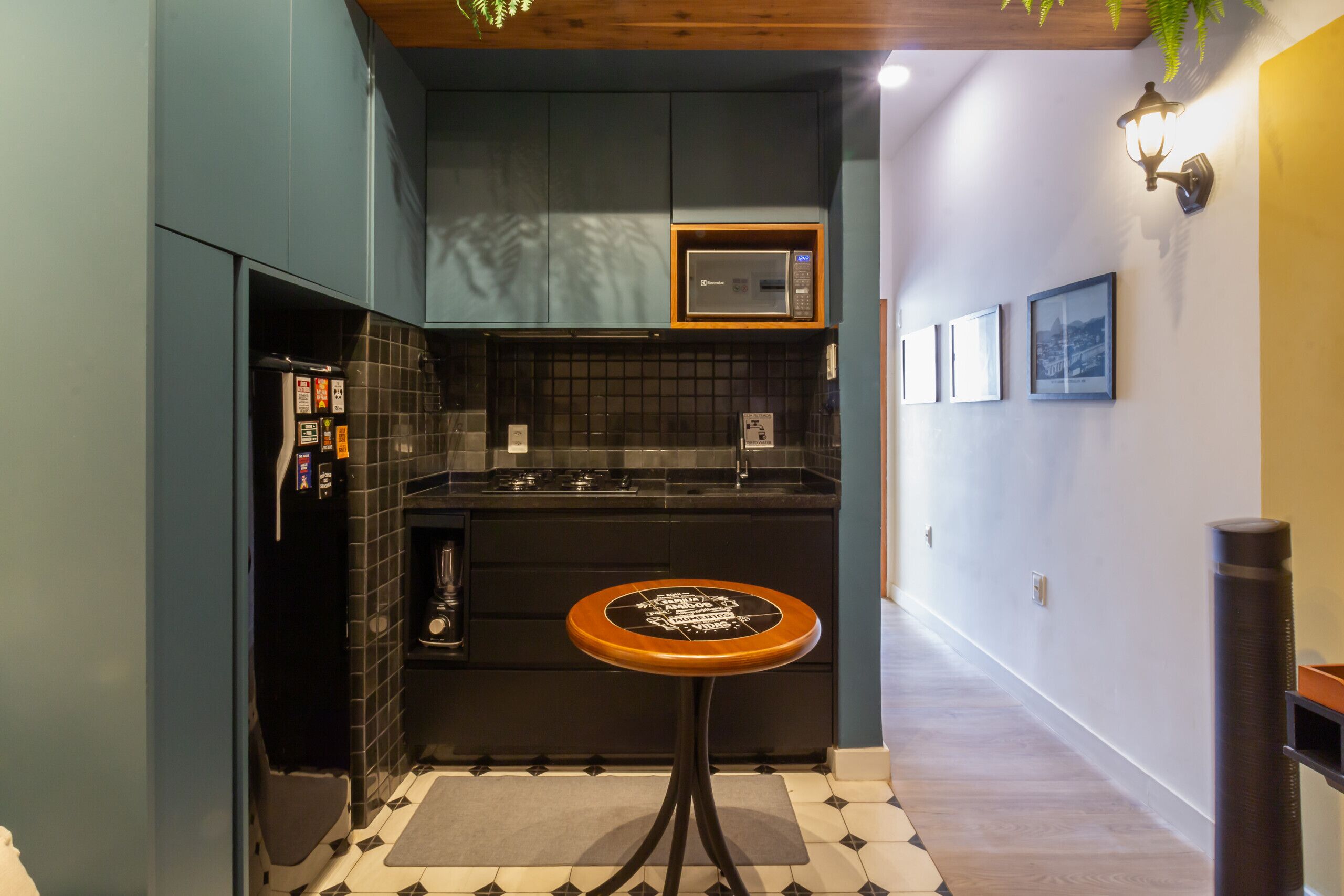 A compact kitchen with a microwave, a sink, and a small table.