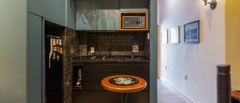 A compact kitchen with a microwave, a sink, and a small table.